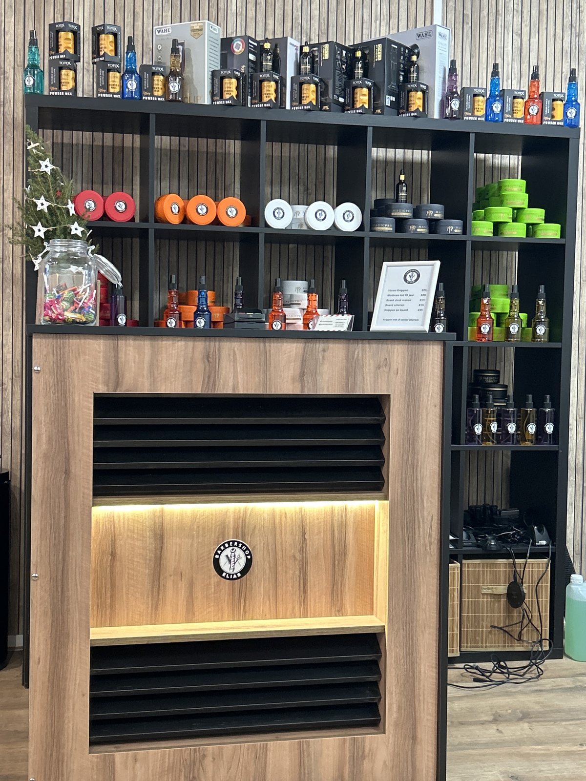 Houten toonbank met verlichting en een kast vol haar- en baardproducten